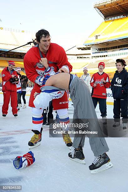 Alex Ovechkin of the Washington Capitals play fights with a kid during a family skate following practice for the 2011 NHL Bridgestone Winter Classic...