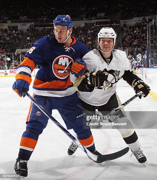 Arron Asham of the Pittsburgh Penguins skates against Zenon Konopka of the New York Islanders at the Nassau Coliseum on December 29, 2010 in...