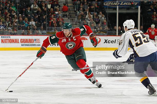 Mikko Koivu of the Minnesota Wild attempts to make a move around defense Shane O'Brien of the Nashville Predators during the game at Xcel Energy...