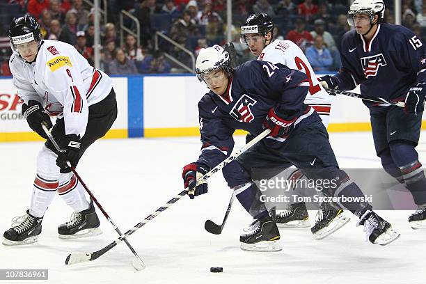 Forward Mitch Callahan of USA tries to fend off Swiss players as he attacks during the 2011 IIHF World U20 Championship game between USA and...