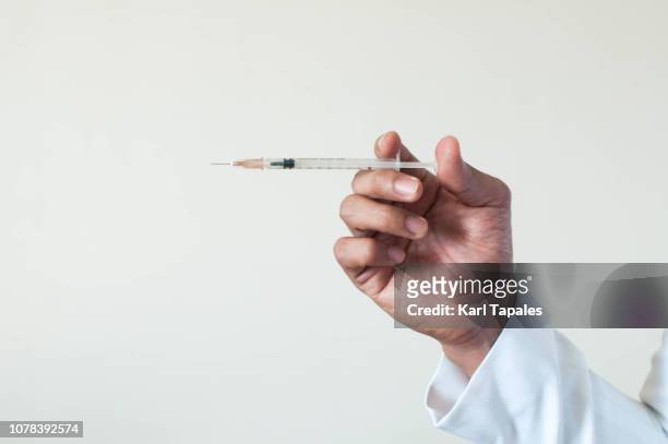 a doctor is ready to give a vaccination - needle stock pictures, royalty-free photos & images