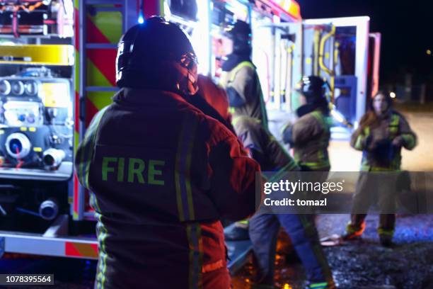 firefighters taking equipment from fire truck and preparing - fire rescue stock pictures, royalty-free photos & images