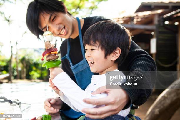 father and son are making fun barbecue items - bbq family park imagens e fotografias de stock