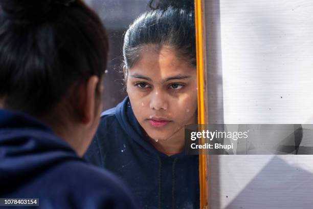 cute girl washing her face and looking in the mirror - woman make up face wipes not men stock pictures, royalty-free photos & images