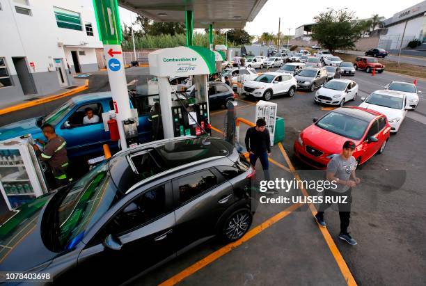 Hundreds of motorists queue to buy gasoline at a station in Guadalajara, Jalisco State, on January 6, 2019 as shortages have also been reported in...