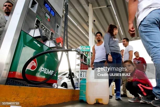 People buy gasoline at a station in Guadalajara, Jalisco State, on January 6, 2019 as shortages have also been reported in several other Mexican...