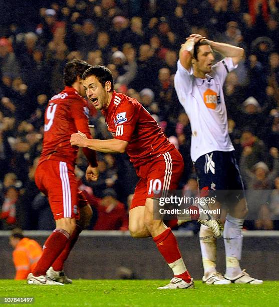 Joe Cole of Liverpool celebrates scoring the winning goal as Samuel Ricketts of Bolton shows his dejection during the Barclays Premier League match...