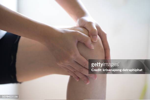 woman knee ache - female knee pain stock-fotos und bilder