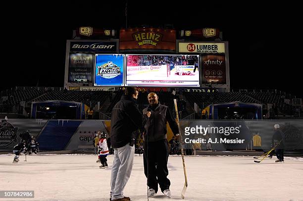 Hockey Hall of Famer Grant Fuhr is interviewed as he plays hockey with area youth hockey players on the GEICO rink prior to the Pittsburgh Penguins...
