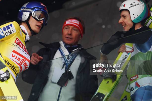 Thomas Morgenstern of Austria disusses with Walter Hofer, FIS race director, and Simon Ammann of Switzerland arrives for the training for the FIS Ski...