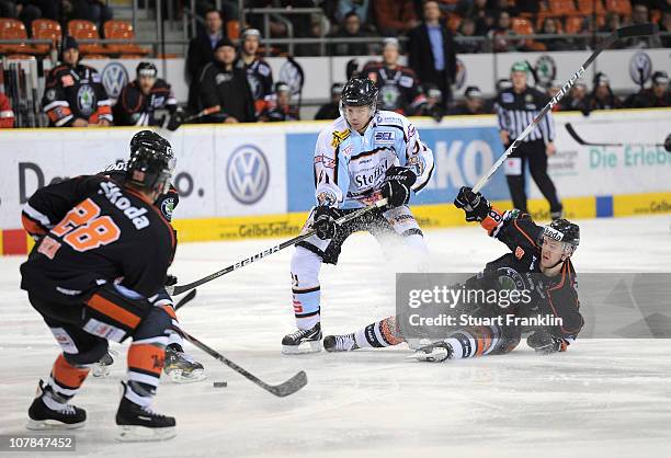 Rene Roethke of Straubing is challenged by Kai Hospelt of Wolfsburg during the DEL match between Grizzly Adams Wolfsburg and Straubing Tigers at the...