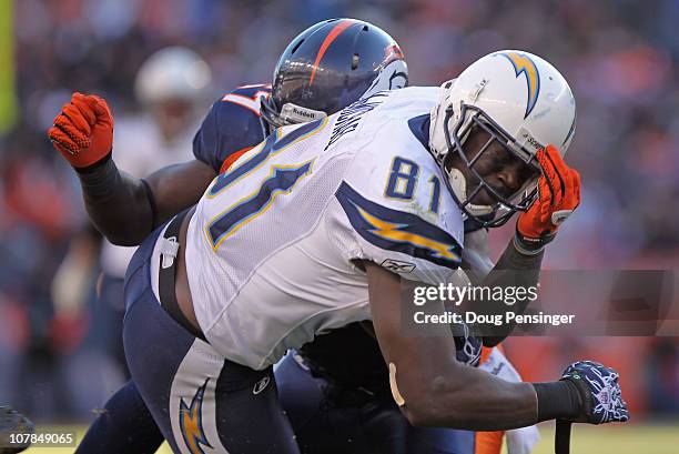 Wide receiver Randy McMichael of the San Diego Chargers makes a 17 yard first down reception and is tackled by Mario Haggan of the Denver Broncos at...