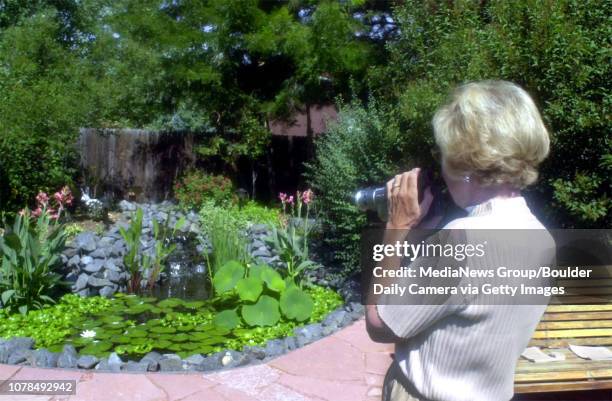 Phyllis Hood from Centennial, video tapes Steve Ashe's Koi pond in his backyard, during the Koi pond tour on Saturday.