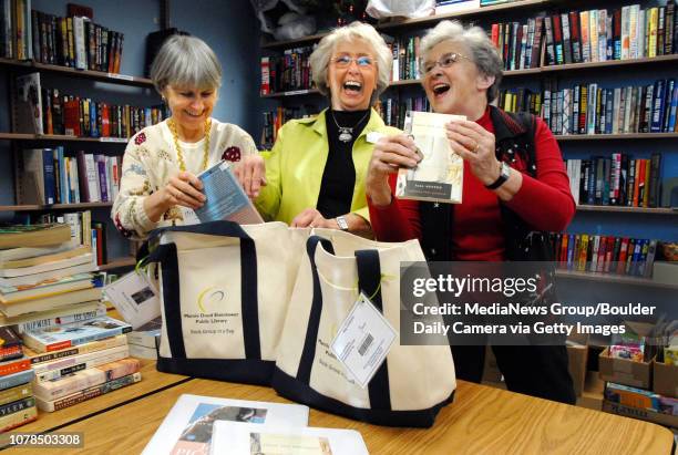 Library Friends Robyn Duda, left, Dorothy J. Ruff and Carrie Schulte laugh as they put books and other items bags for the Book Club in a Bag program...