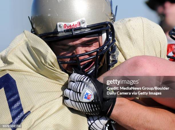 Legacy High School's Nick Kasa blocks other players during football practice at the school on Tuesday.