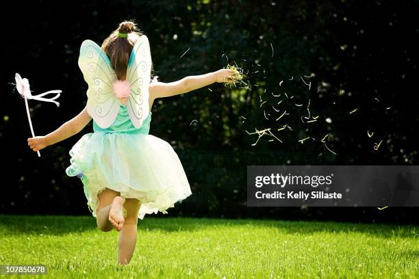 a girl in fairy costume running and thowing grass - enfant deguisement photos et images de collection