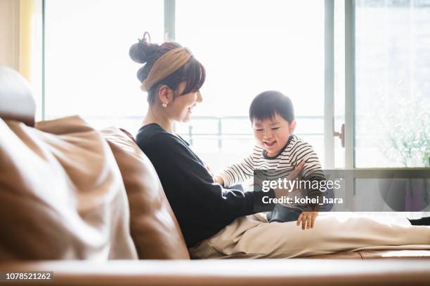 mother and baby relaxed on the sofa - japanese mom stock pictures, royalty-free photos & images