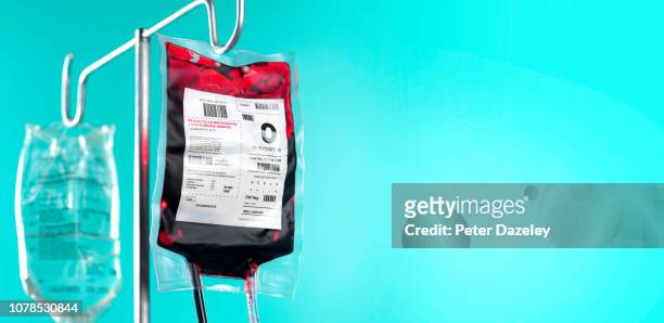 iv blood bag and saline drip on hospital stand with copy space - drip bag stockfoto's en -beelden