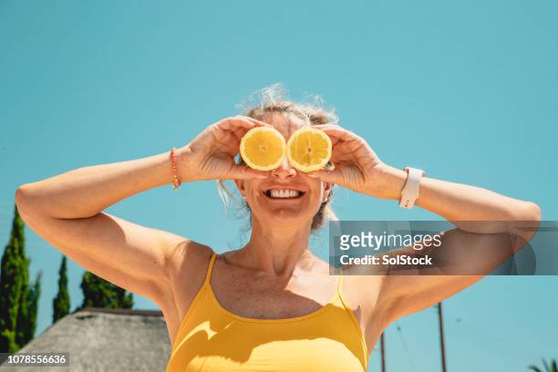 wanneer leven je geeft citroenen - smiling mature eyes stockfoto's en -beelden