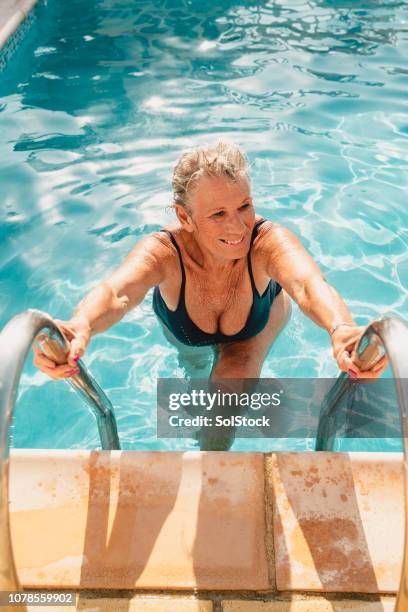 senior woman getting out of the pool - woman swimsuit happy normal stock pictures, royalty-free photos & images