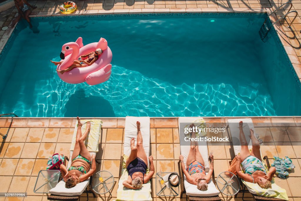 Senior femenino relajante junto a la piscina