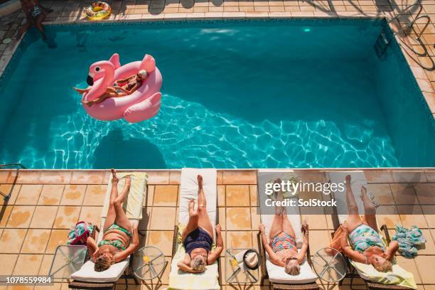 senior women relaxing by the poolside - friends poolside stock pictures, royalty-free photos & images