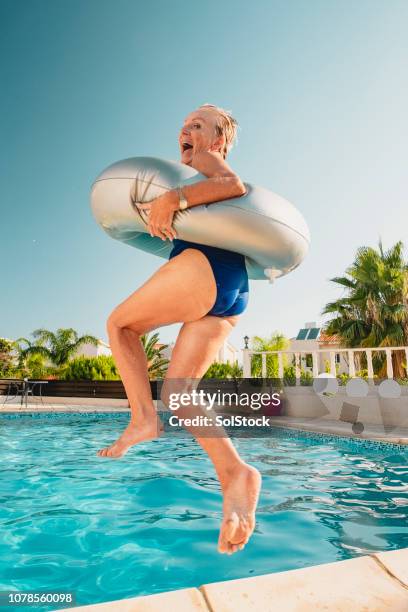ältere frau in den pool springen - old woman in swimsuit stock-fotos und bilder