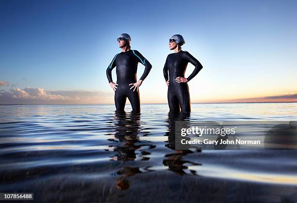 male and female triathlete after swimming event - wetsuit stock pictures, royalty-free photos & images