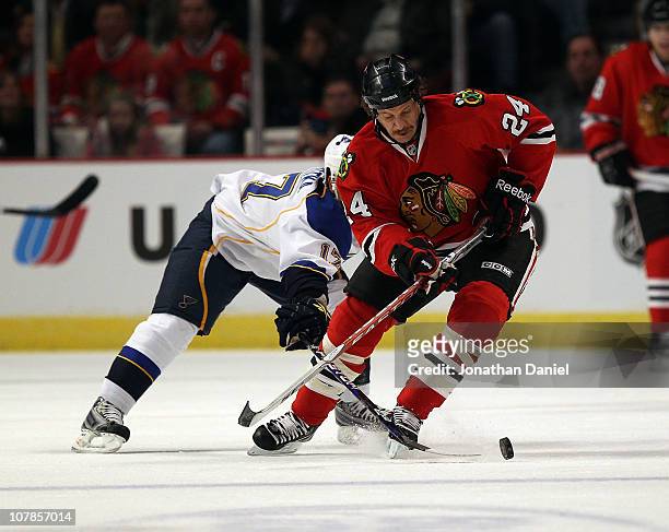 Nick Boynton of the Chicago Blackhawks tries to control the puck under pressure from Vladimir Sobotka of the St. Louis Blues at the United Center on...