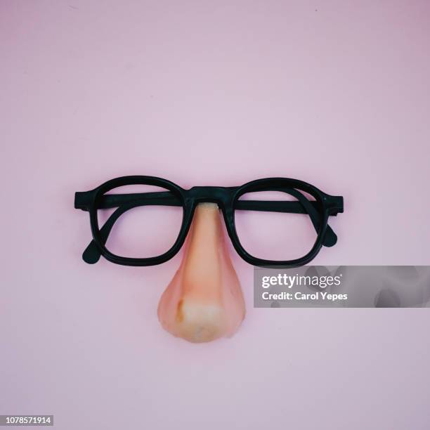 funny plastic glasses in pink background - mask disguise stockfoto's en -beelden