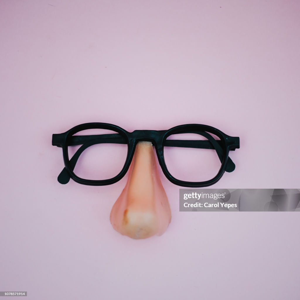 Funny plastic glasses in pink background