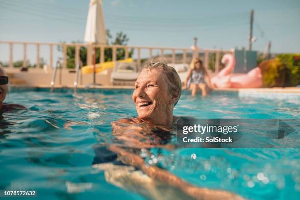 ältere frau genießen sommerurlaub - schwimmen schwimmbad stock-fotos und bilder