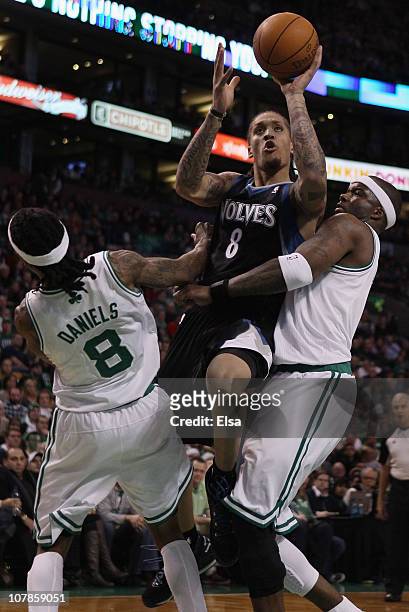 Michael Beasley of the Minnesota Timberwolves is called for an offensive foul as he drives to the net and knocks into Marquis Daniels and Jermaine...