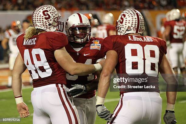 Owen Marecic, Jeremy Stewart and Konrad Reuland of the Stanford Cardinal celebrate after Stewart scored a 60-yard rushing touchdown in the first...