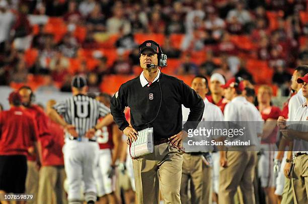 Stanford head coach Jim Harbaugh takes a look at the scoreboard as the Cardinal faced Virginia Tech during the Discover Orange Bowl on Monday,...
