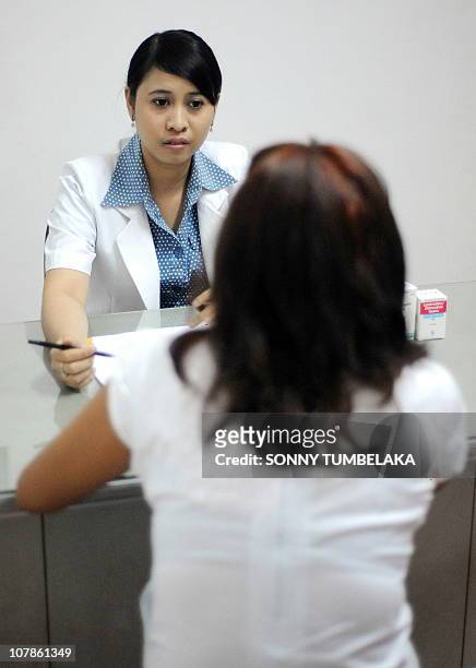 Indonesian doctor Desak Made Putri gives a medical consultation to a HIV positive patient at a clinic in Denpasar on the resort island of Bali on...