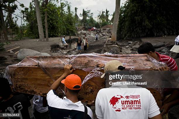 Residents move a coffin as the cemetery was covered by volcanic material after volcanic mudflows forced evacuations on January 4, 2011 in Magelang,...