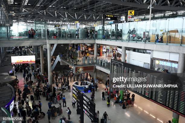 Travellers arrive at the Suvarnabhumi international airport in Bangkok on January 7, 2019. - An injunction has been filed at Bangkok's Criminal Court...