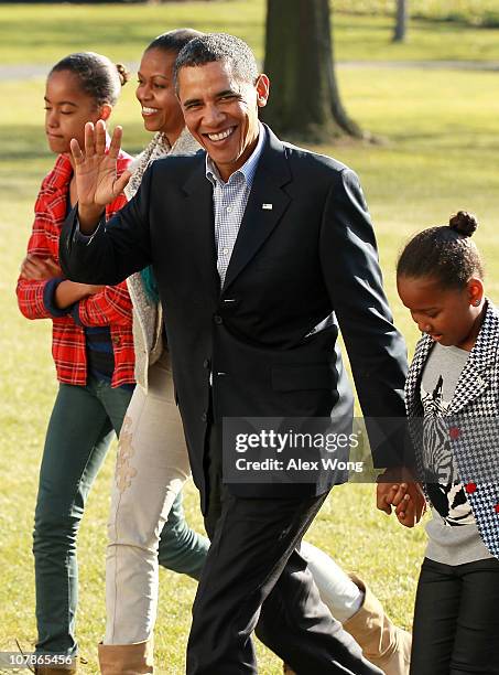 President Barack Obama walks on the South Law with first lady Michelle , daughters Sasha and Malia after they returned at the White House January 4,...