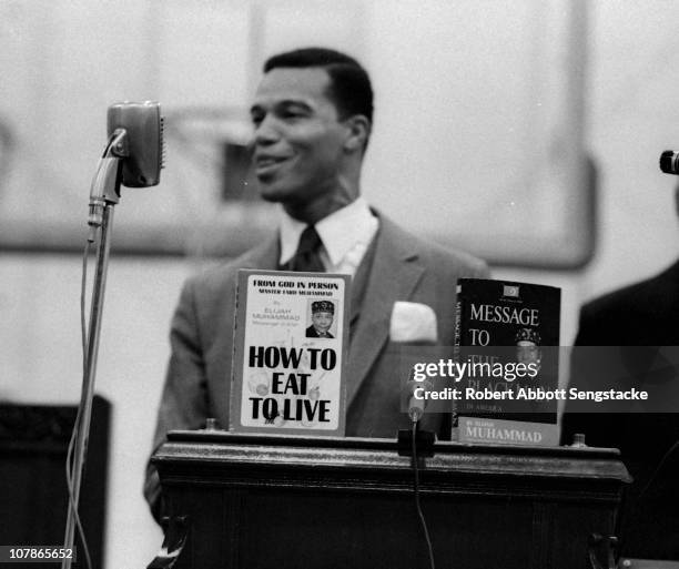 Nation of Islam leader Louis Farrakhan speaks from behind a lecturn at Tennessee State University, Nashville, Tennessee, 1969. On the lecturn are a...