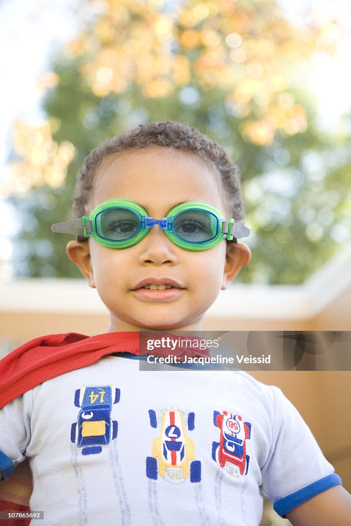 Boy wearing red cape and goggles