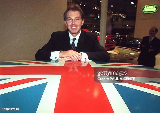 British Prime Minister Tony Blair leans on the Union Jack painted roof of a British Leyland Mini Cooper motor car, 14 October during a visit to the...