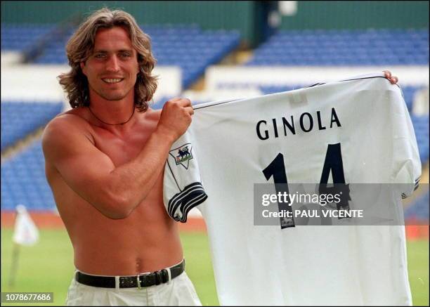 French soccer star David Ginola shows off 15 July, his new number 14 shirt that he will wear for his new club Tottenham Hotspur after signing for the...