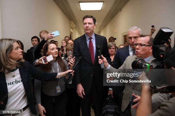 Former Federal Bureau of Investigation Director James Comey is surrounded by reporters after testifying to the House Judiciary and Oversight and...