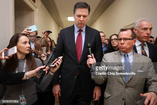 Former Federal Bureau of Investigation Director James Comey is surrounded by reporters after testifying to the House Judiciary and Oversight and...