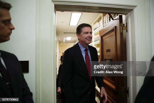 Former Federal Bureau of Investigation Director James Comey comes out of the hearing room at the Rayburn House Office Building after testifying to...