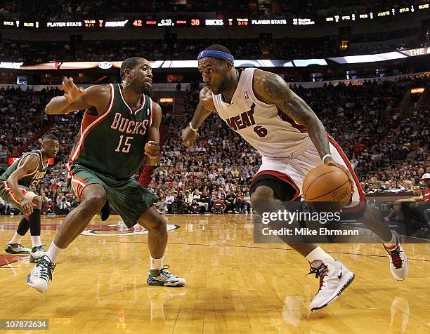 LeBron James of the Miami Heat dribbles around John Salmons of the Milwaukee Bucks during a game at American Airlines Arena on January 4, 2011 in...