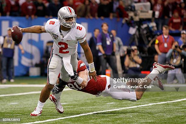 Terrelle Pryor of the Ohio State Buckeyes looks to avoid the sack attempt by Jake Bequette of the Arkansas Razorbacks in the second half during the...