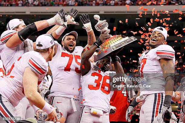 Brian Rolle of the Ohio State Buckeyes holds the trophy as the Buckeyes celebrate their 31-26 victory against the Arkansas Razorbacks during the...