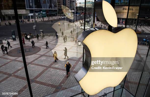 The Apple logo is seen on the window at an Apple Store on January 7, 2019 in Beijing, China. Apple Inc. Lowered its revenue guidance last week,...